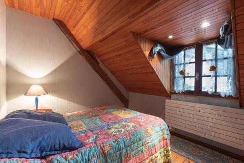 a attic bedroom with a bed and a window at Cottage au Calme in Gèdre