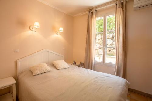a bedroom with a bed with two pillows on it at Restanques de Saint Tropez - arums in Grimaud