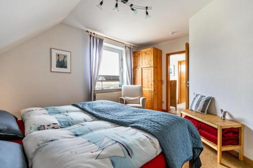 a bedroom with a bed and a desk and a window at Bi uns to hus - Obendsünn in Nordstrand