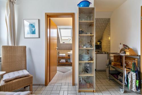 a living room with a door open to a kitchen at Bi uns to hus - Obendsünn in Nordstrand