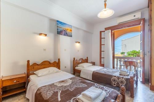 a bedroom with two beds and a balcony at Mires House Side Ground Floor 3 in Agios Gordios