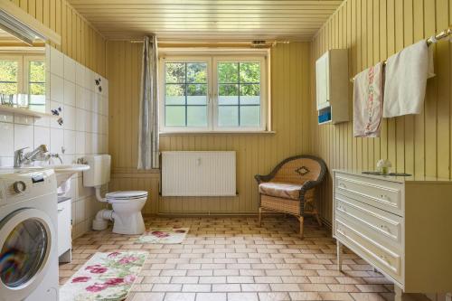 a bathroom with a toilet and a sink and a washing machine at Grosszügiges Ferienhaus mit Wald in Gerdau