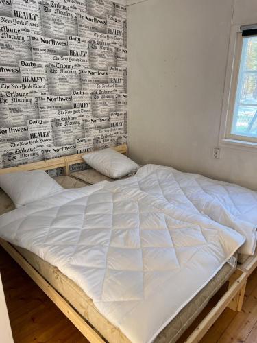 a bed in a room with a wall of newspapers at Mysig Stuga in Sveg