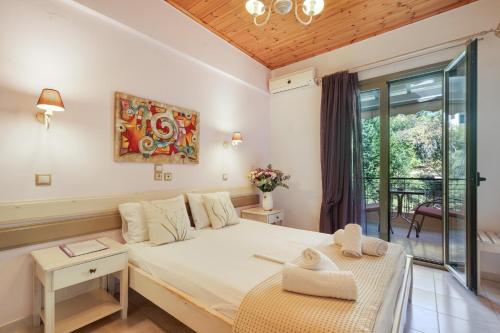 a bedroom with a bed and a large window at Nontas Homes 36 in Kalamitsi