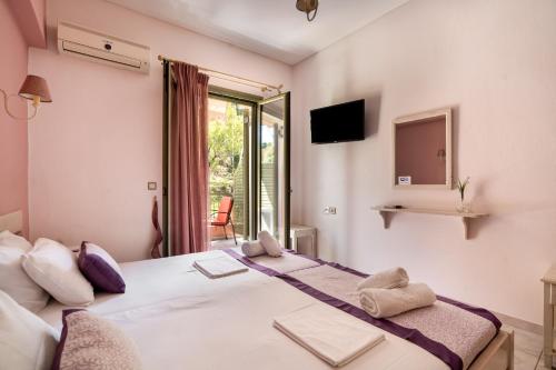 a bedroom with a large bed and a window at Nontas Home 26 in Kalamitsi