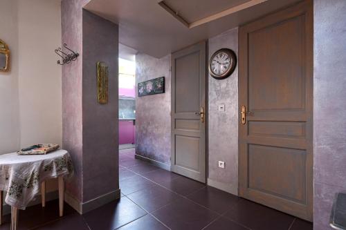 a hallway with a door and a clock on the wall at Les Oliviers in Cassis