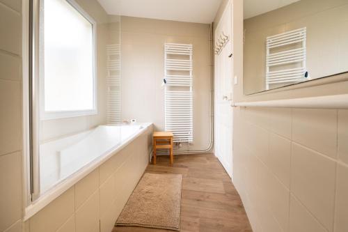 a bathroom with a bath tub and a window at Maison Ty Sioul - proche plage in Quiberon