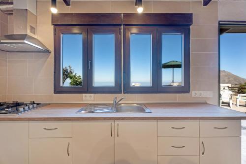 a kitchen with a sink and some windows at Casa Eyden Sunset View in Arona