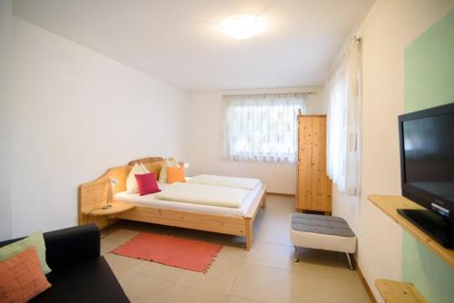a small room with a bed and a television at Peter Paul Gartenapt. Palme in Appiano Sulla Strada Del Vino