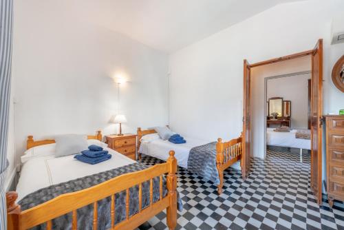 a bedroom with two beds and a mirror at Can Joi in Sóller