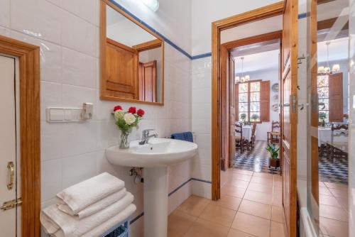 a bathroom with a sink and a vase of flowers at Can Joi in Sóller