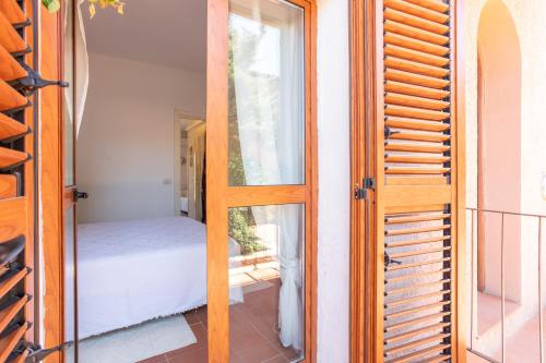 a door to a room with a bed and a window at Casa Carlotta in Costa Paradiso in Costa Paradiso