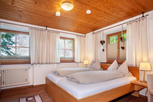 a bedroom with a large white bed with windows at Allpano Pension und Ferienwohnungen in Dietmannsried