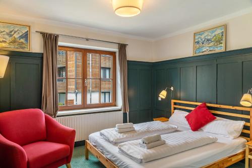 a bedroom with a bed and a red chair at Chalet Sonneck - Seefeld in Seefeld in Tirol