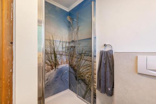 a bathroom with a shower with a picture of the beach at Ferienhaus von Osten in Burg