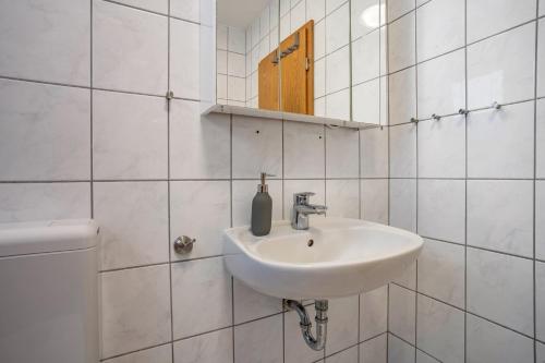 a white bathroom with a sink and a mirror at Haus Frohsinn - Wohnung 3 in Binz