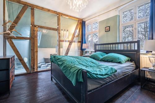 a bedroom with a bed with green sheets and a window at Villa Seeblick in Rheinsberg