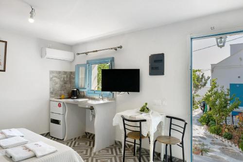 a kitchen with a table and chairs in a room at Politimi Studio N8 in Amorgos