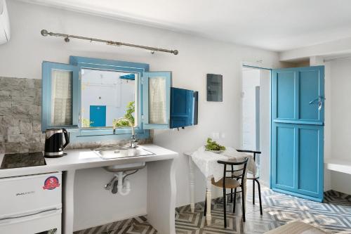 a kitchen with blue cabinets and a sink at Politimi Studio N8 in Amorgos