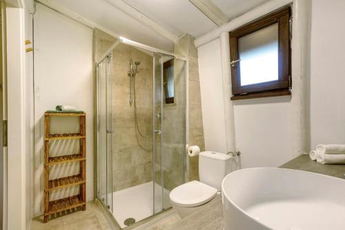 a bathroom with a shower and a toilet and a tub at Berghütte in Ulrichstein