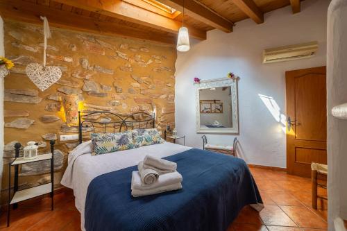 a bedroom with a bed and a stone wall at Tenguerengue in Laroya