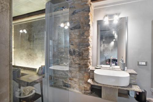 a bathroom with a sink and a glass shower at Modern Heritage House in Imperia