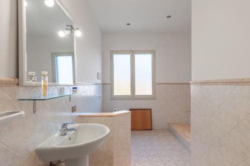 a white bathroom with a sink and a shower at Appartamento in Villa Marlory in Monreale