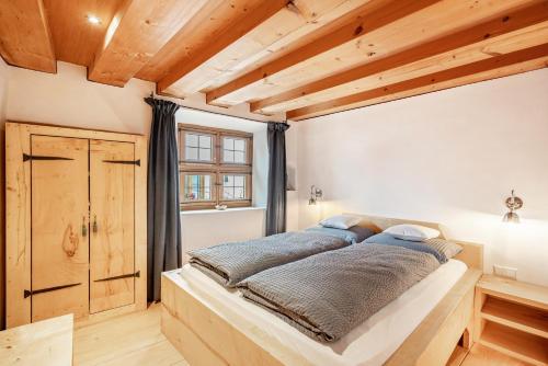 a large bed in a room with wooden ceilings at Apartment Zwiefirst in Grafing