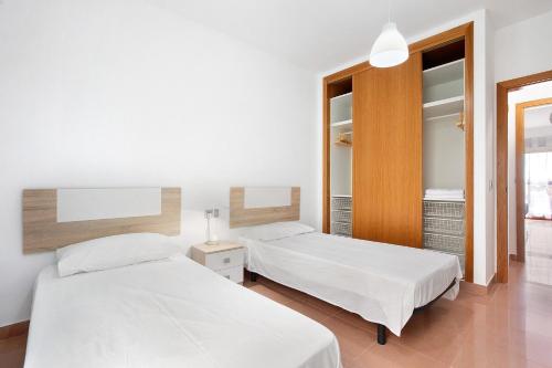 a bedroom with two beds and a mirror at Casa Rosi 1 in Puerto del Rosario