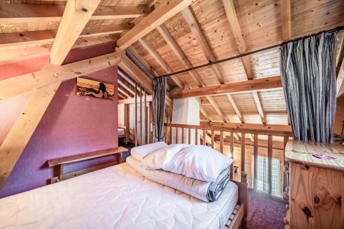 a bedroom in a log cabin with a bed at Chalet 4p Classique-Les Ancolies in Verchaix