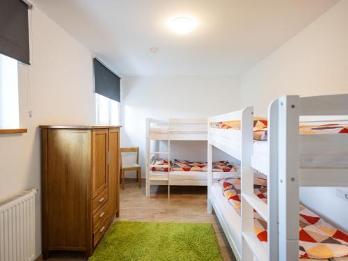 a bedroom with two bunk beds and a green rug at Conzen Hof am Hennesee in Erflinghausen