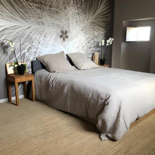 a bedroom with a bed with a white comforter at Gîte Bonaty in Soulgé-sur-ouette