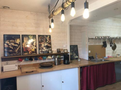 una cucina con un piano di lavoro su cui sono appesi dei quadri. di Gîte Bonaty a Soulgé-sur-ouette