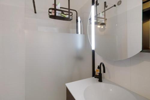 a white bathroom with a sink and a mirror at Superbe appartement centre Ajaccio in Ajaccio