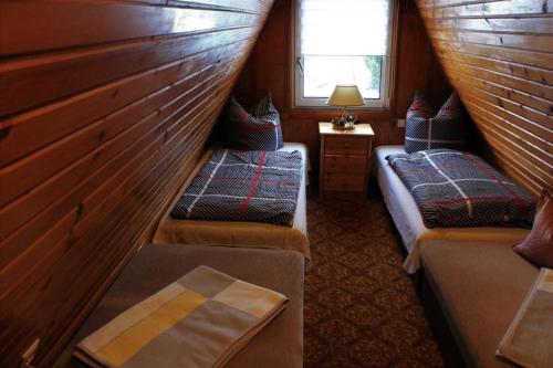 a attic room with two beds and a window at Ferienhaus Wittmann in Kurort Oberwiesenthal