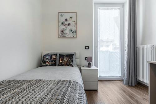a white bedroom with a bed and a window at Villa Vacanze Pink Lady in Tuenno