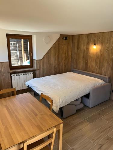 a bedroom with a bed and a wooden wall at L’Angolo del Paradiso in Cogne