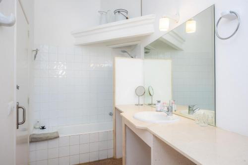 a white bathroom with a sink and a mirror at Can Manuel in Felanitx