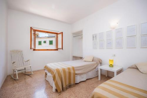 a bedroom with two beds and a window at Can Manuel in Felanitx