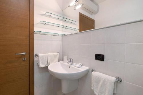 a white bathroom with a sink and a mirror at Ultimo Tiro - app Secondo Tiro in Cisano sul Neva