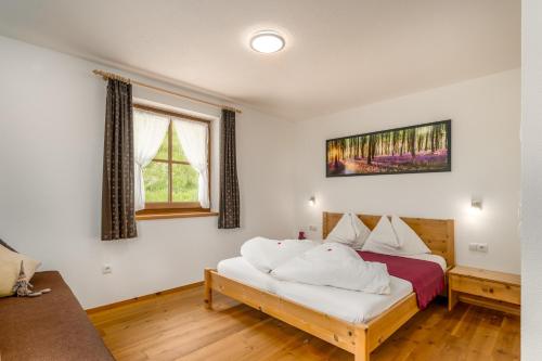 a bedroom with a bed with white sheets at Tratterhof Apt Astjoch in Vandoies