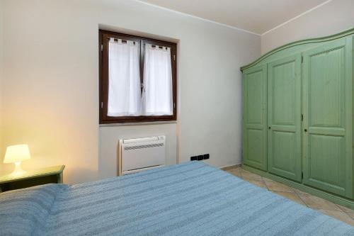 a bedroom with a blue bed and a window at Ultimo Tiro - app Secondo Tiro in Cisano sul Neva