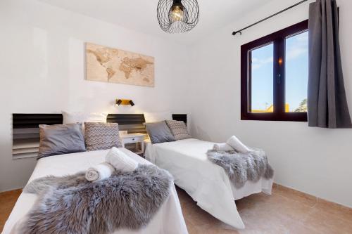 a bedroom with two beds and a window at Te Mahana Nei House in Costa Calma
