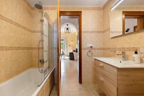 a bathroom with a tub and a sink and a shower at Te Mahana Nei House in Costa Calma
