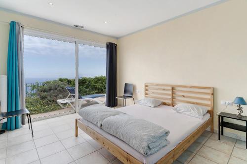 a bedroom with a bed and a large window at Casa Sirius in Tijarafe