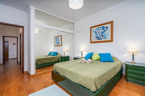 a bedroom with two beds and a large mirror at Villa Raposo em Porches in Porches