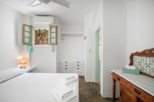 a white bedroom with a bed and a dresser at Karavi in Rámos