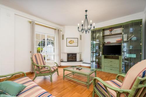 a living room with a couch and chairs and a tv at Villa Raposo in Porches