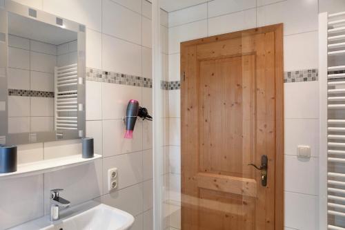 a bathroom with a shower with a wooden door at Ferienwohnung Waxensteinblick in Grainau