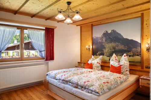 a bedroom with a bed with a painting on the wall at Ferienwohnung Waxensteinblick in Grainau